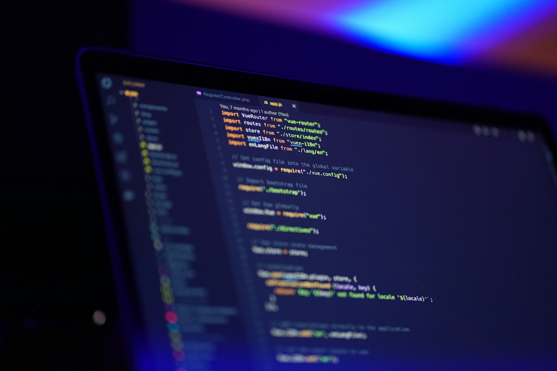 Code on a laptop screen in purple light